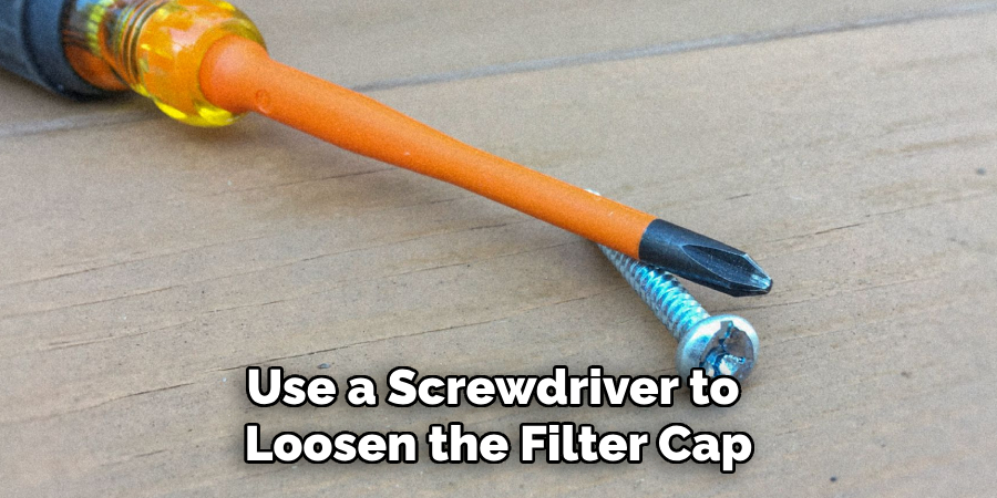 Use a Screwdriver to Loosen the Filter Cap